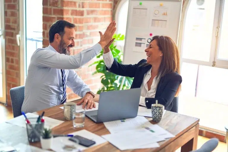 um homem e uma mulher sentados à mesa com um laptop